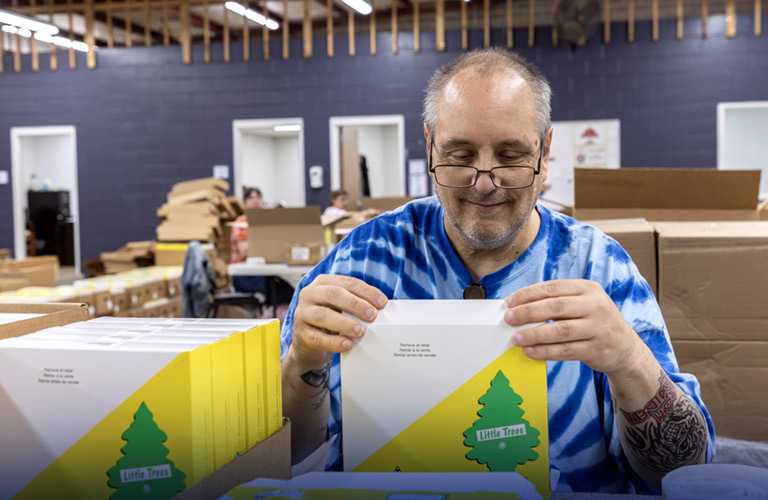 man in glasses sealing an envelope