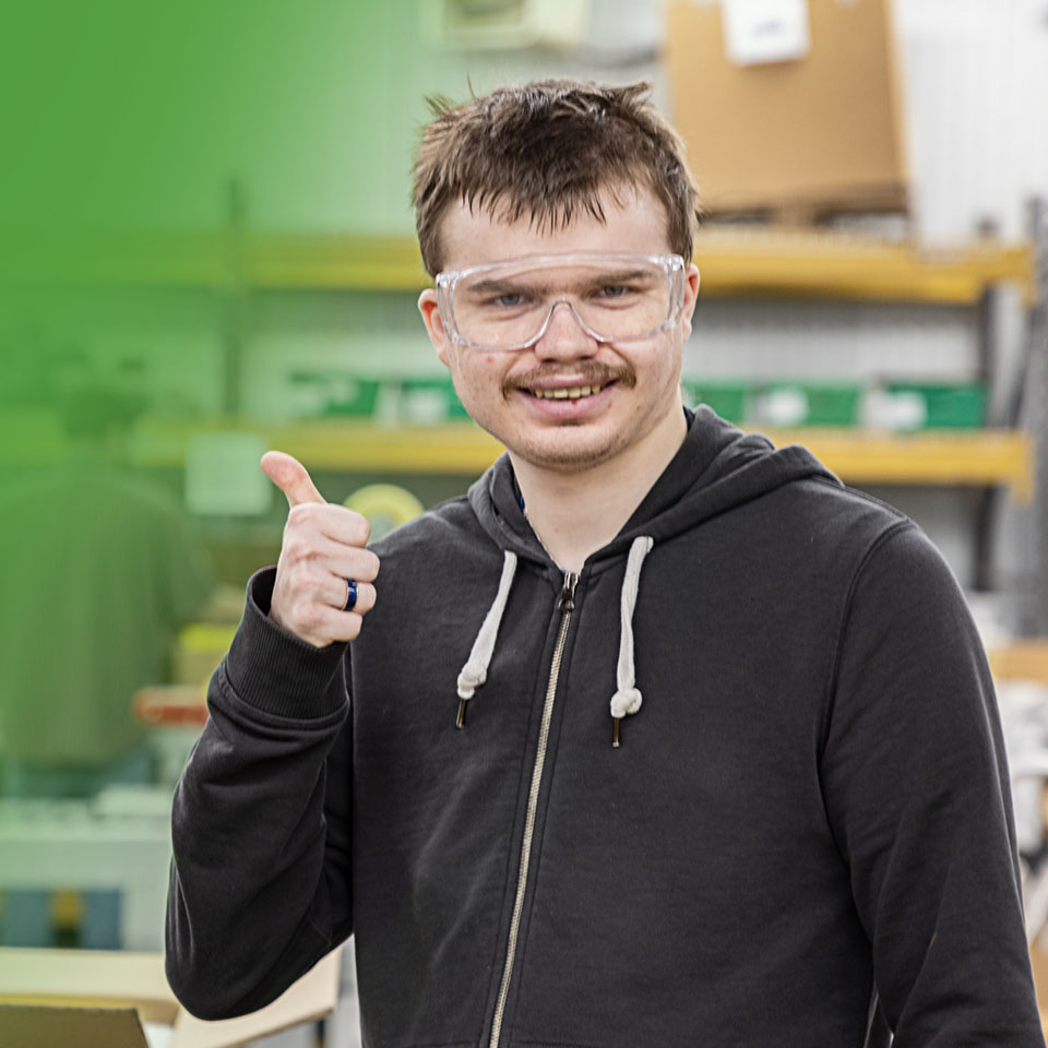 man in safty goggles giving a thumbs up and smiling