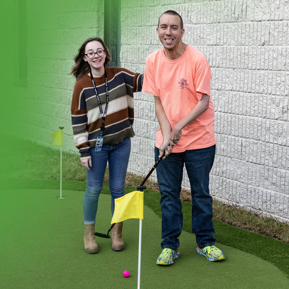 young woman and man playing put-put golf