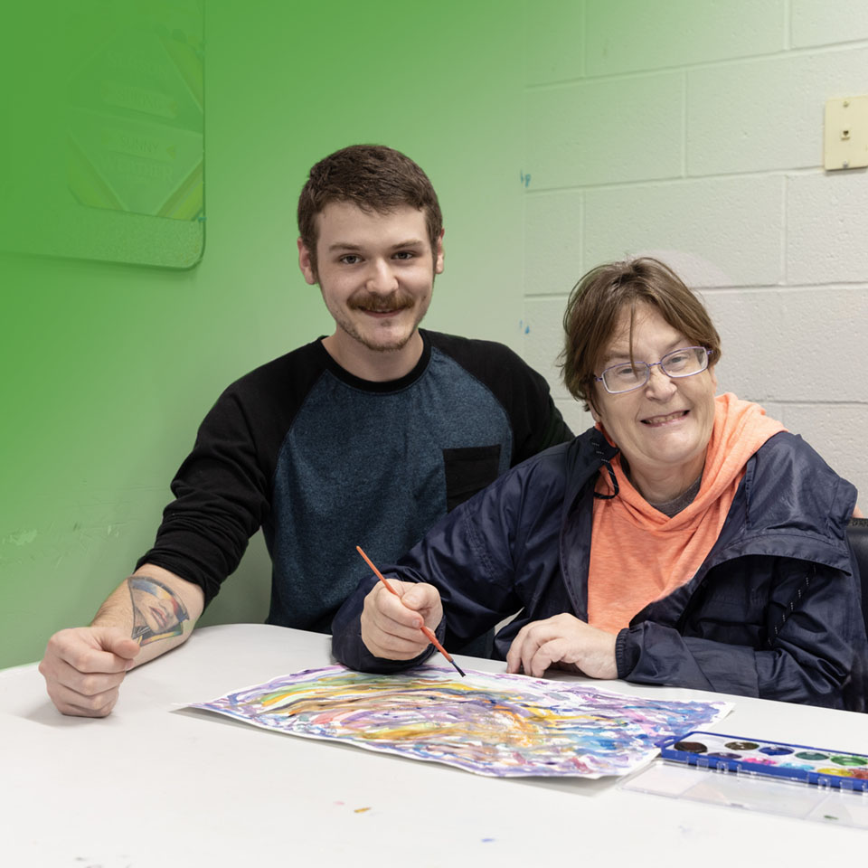 man and woman painting and smiling