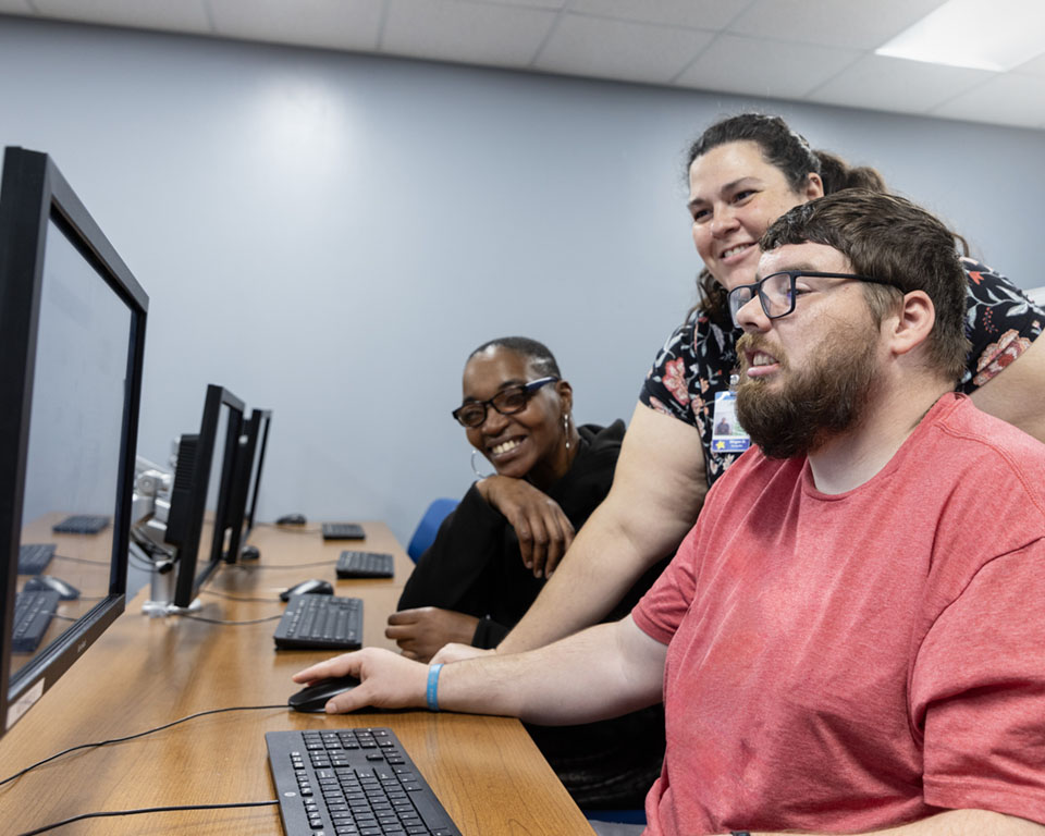 man with two women at computer