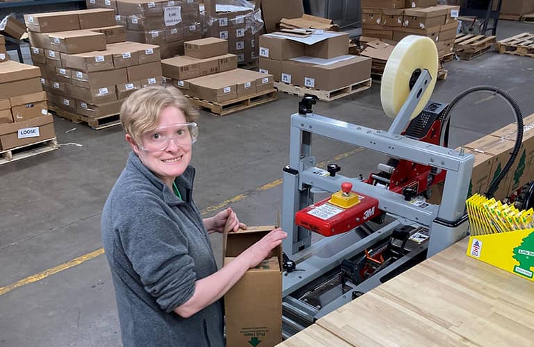 women with a box at a machine