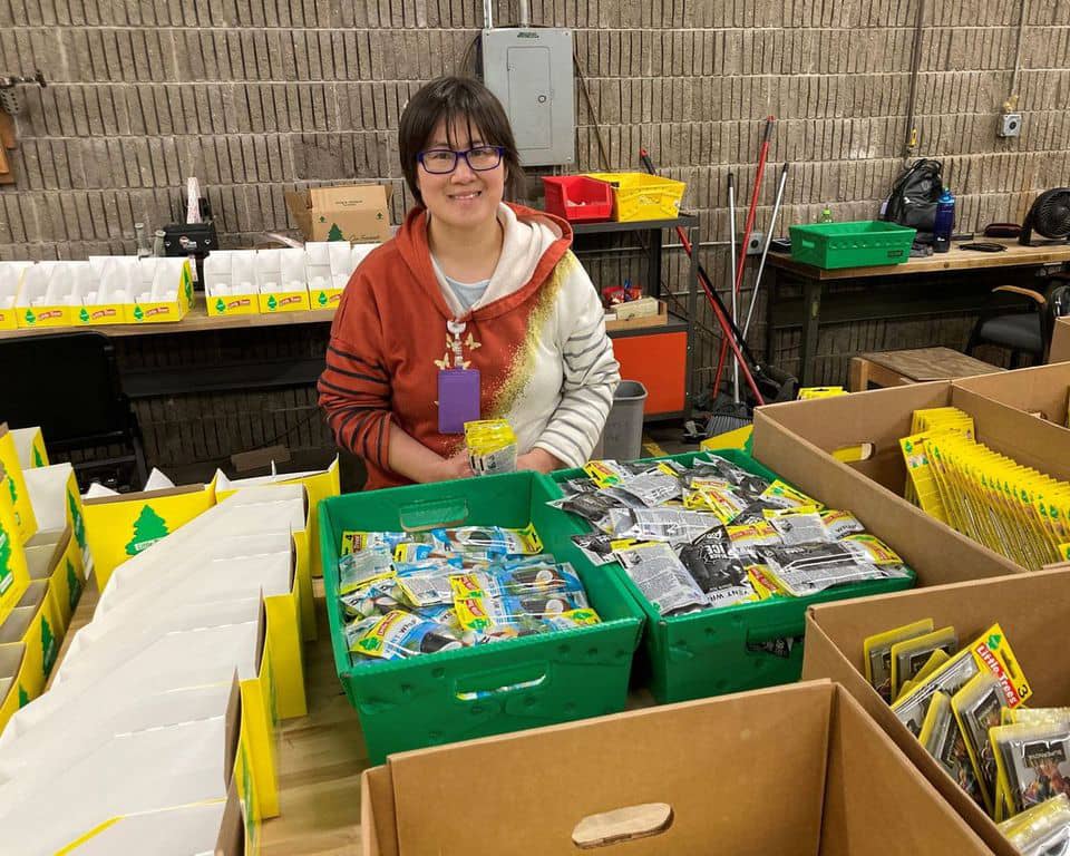 women smiling at camera while sorting materials